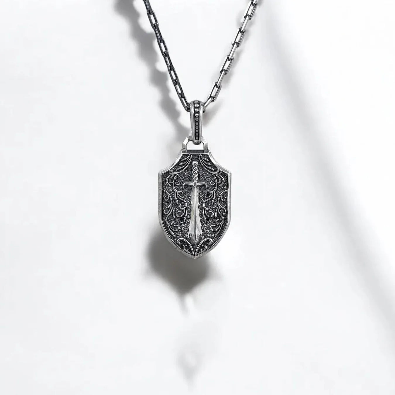 Gothic skull necklace with crowned red eye skull design on the front and sword engraving on the back, crafted from solid sterling silver. This handmade necklace is a wearable piece of art that reflects both dark beauty and inner strength, ideal for engraved gifts and personal keepsakes.