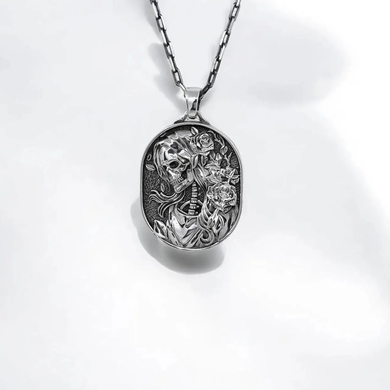 Sterling silver Gothic Skull Cameo Necklace featuring a skeleton portrait surrounded by intricate floral details. This Day of the Dead inspired pendant blends romantic elegance with dark symbolism, making it a perfect piece for lovers of gothic fashion, alternative jewelry, and handcrafted statement accessories.