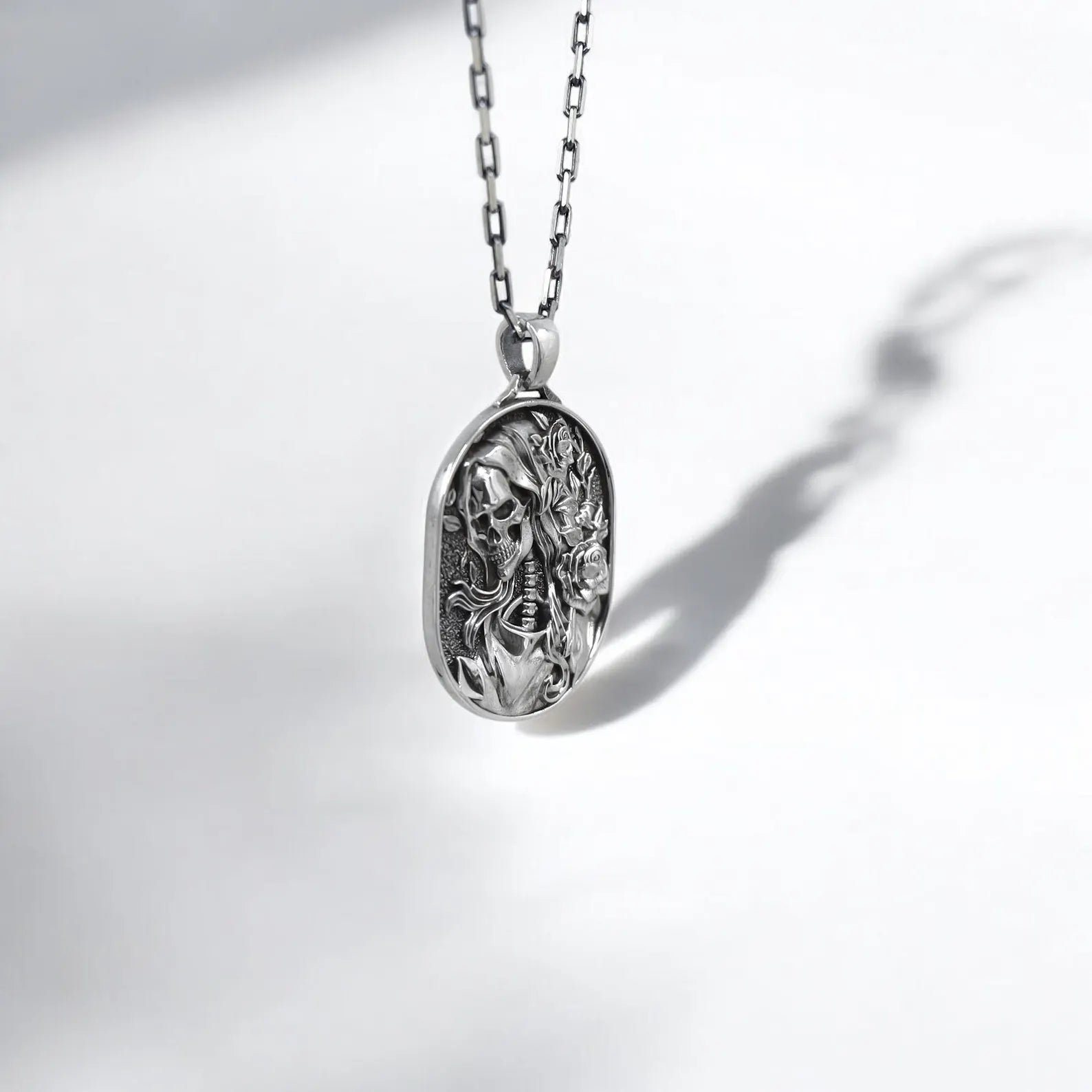 Gothic-inspired sterling silver necklace with an intricately carved skeleton cameo surrounded by roses and leaves. The Eternal Blossom pendant reflects both strength and delicate beauty, making it a powerful symbol of resilience, perfect for dark fashion lovers and alternative jewelry collectors.