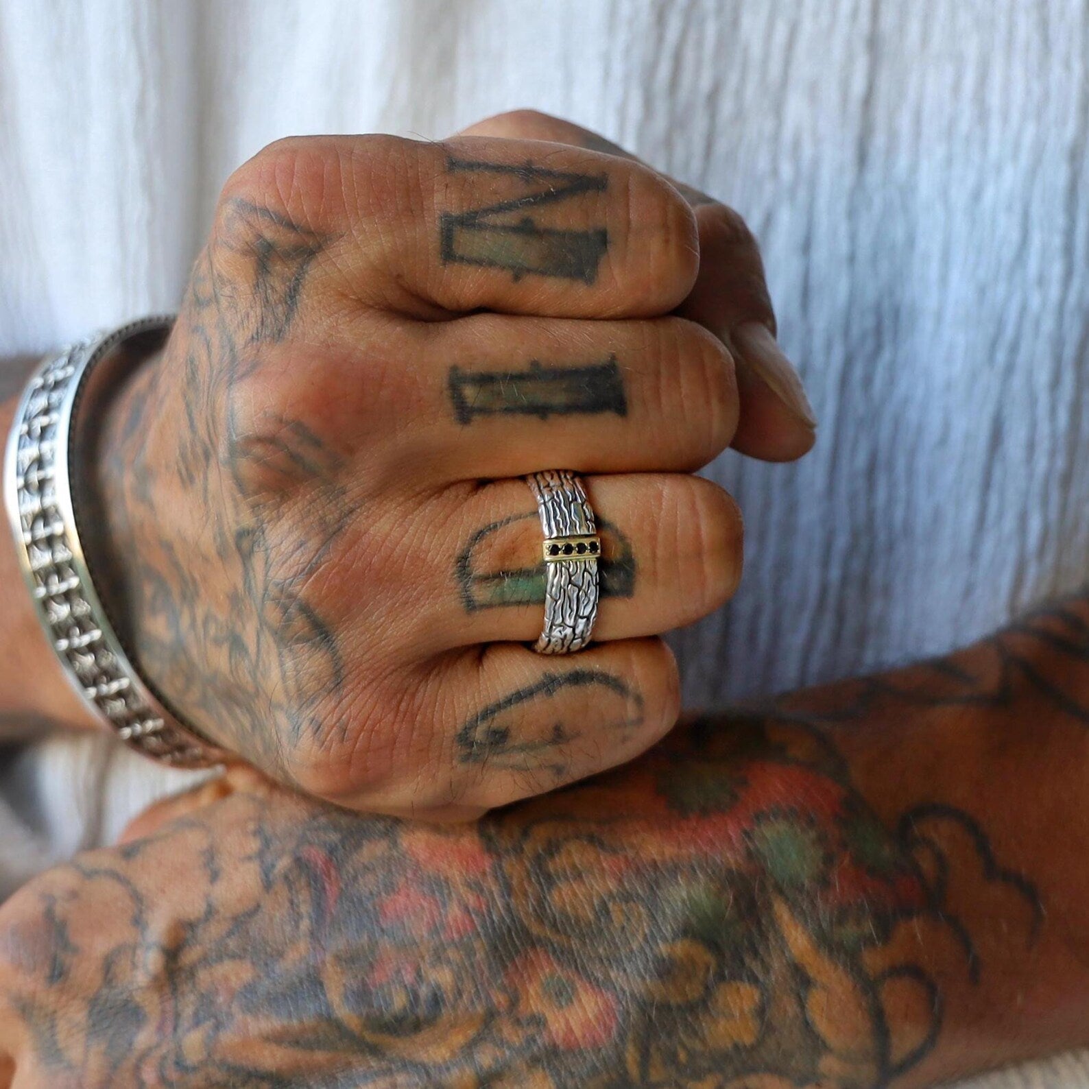 Artisan mens ring crafted from 925 sterling silver, with rich black stones and gold-plated trim embedded along a thick textured band, designed to create a dramatic and masculine accessory perfect for evening wear or bold everyday style.