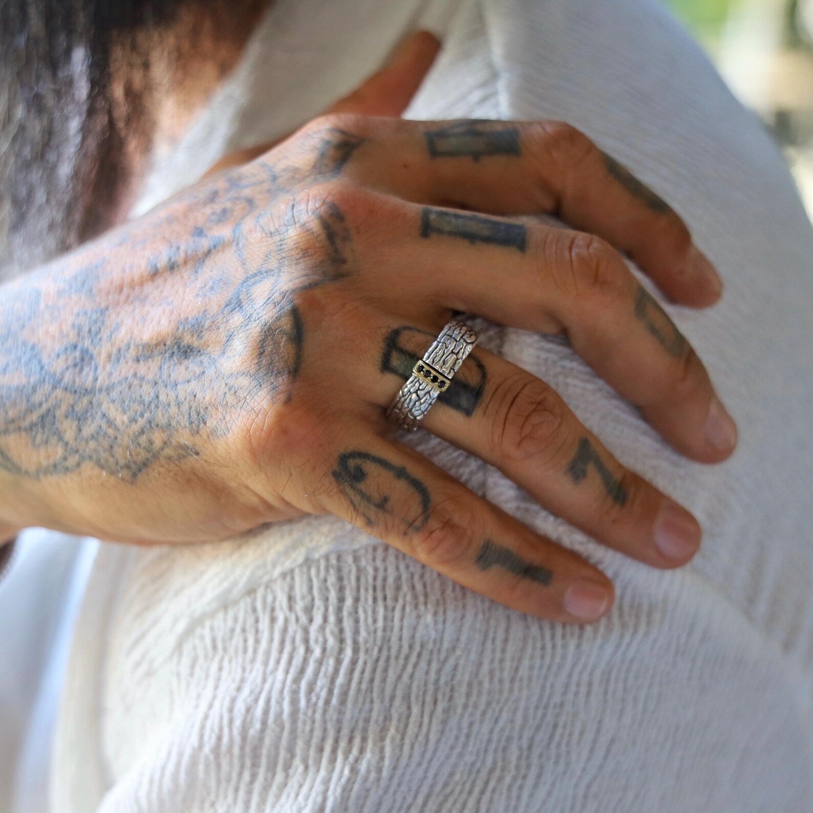 Mens statement ring made of solid sterling silver with a rugged textured surface, highlighted by gold plating and black onyx gemstones, offering a unique balance of power, elegance, and handmade detail for those who love gothic and regal-inspired jewelry.