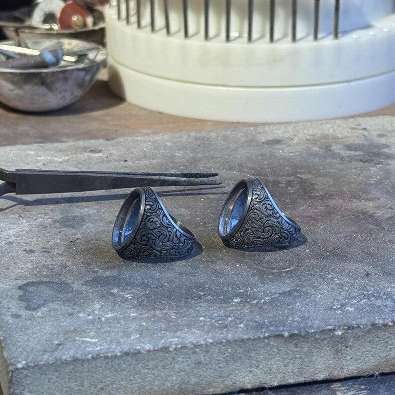 Artistic Baroque-inspired men’s signet ring showcasing ornate floral engravings and a smooth polished turquoise stone centerpiece