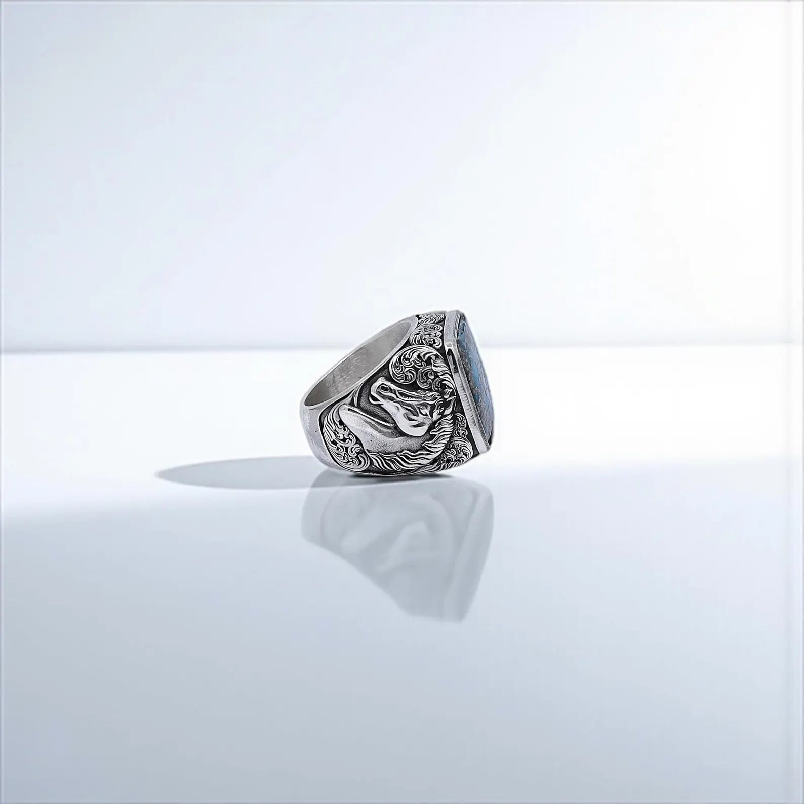 Close-up image of a bold men's ring with blue turquoise stone and detailed horse motif, symbolizing freedom and strength, handcrafted from solid 925 silver for a rustic and timeless look.