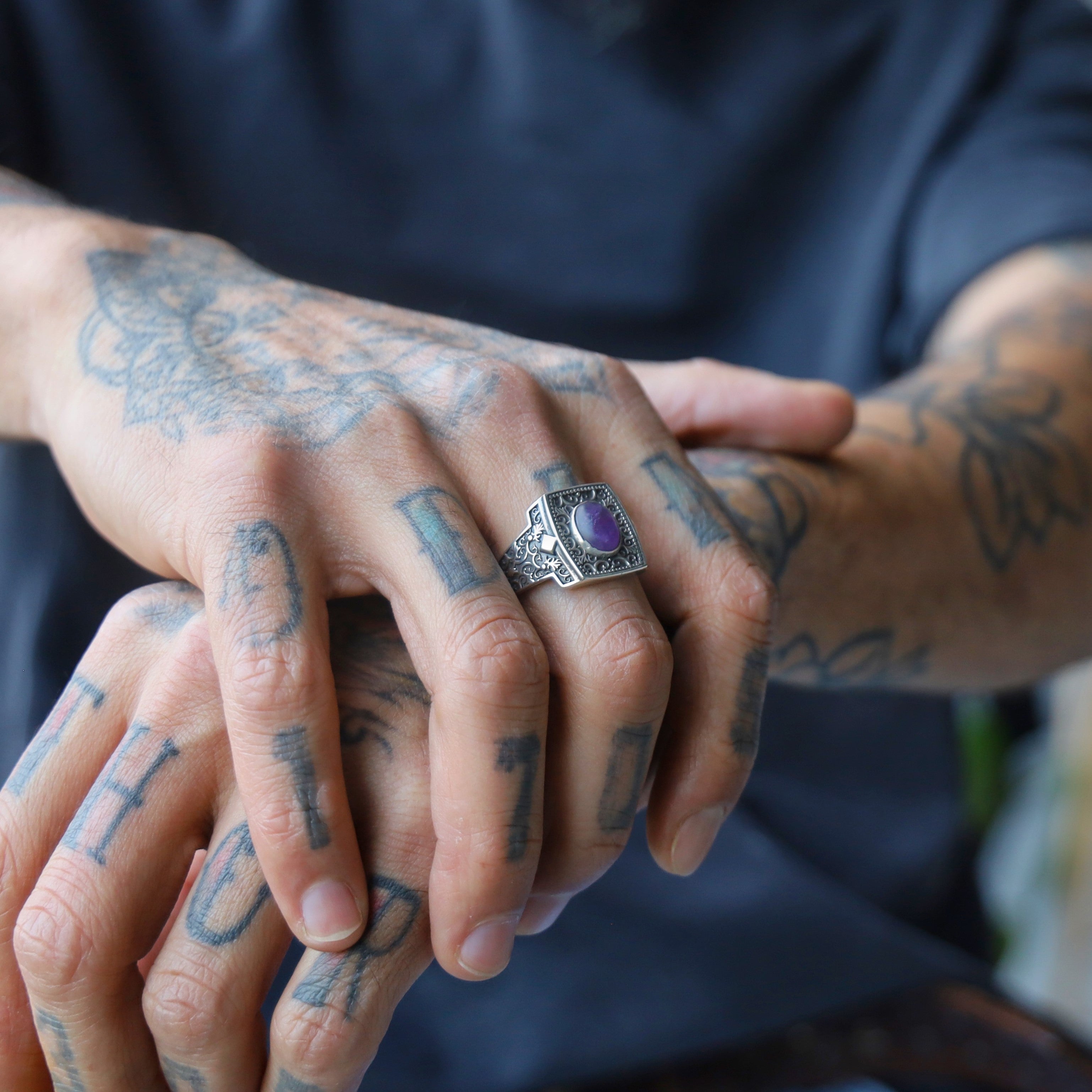 This engraved sterling silver ring showcases a vibrant amethyst gemstone at its center, symbolizing balance, clarity, and protection. The intricate patterns along the wide band evoke historical craftsmanship with a modern twist. Designed for confident men who prefer meaningful, expressive jewelry, this ring is an excellent choice for anniversaries, birthdays, or spiritual milestones.