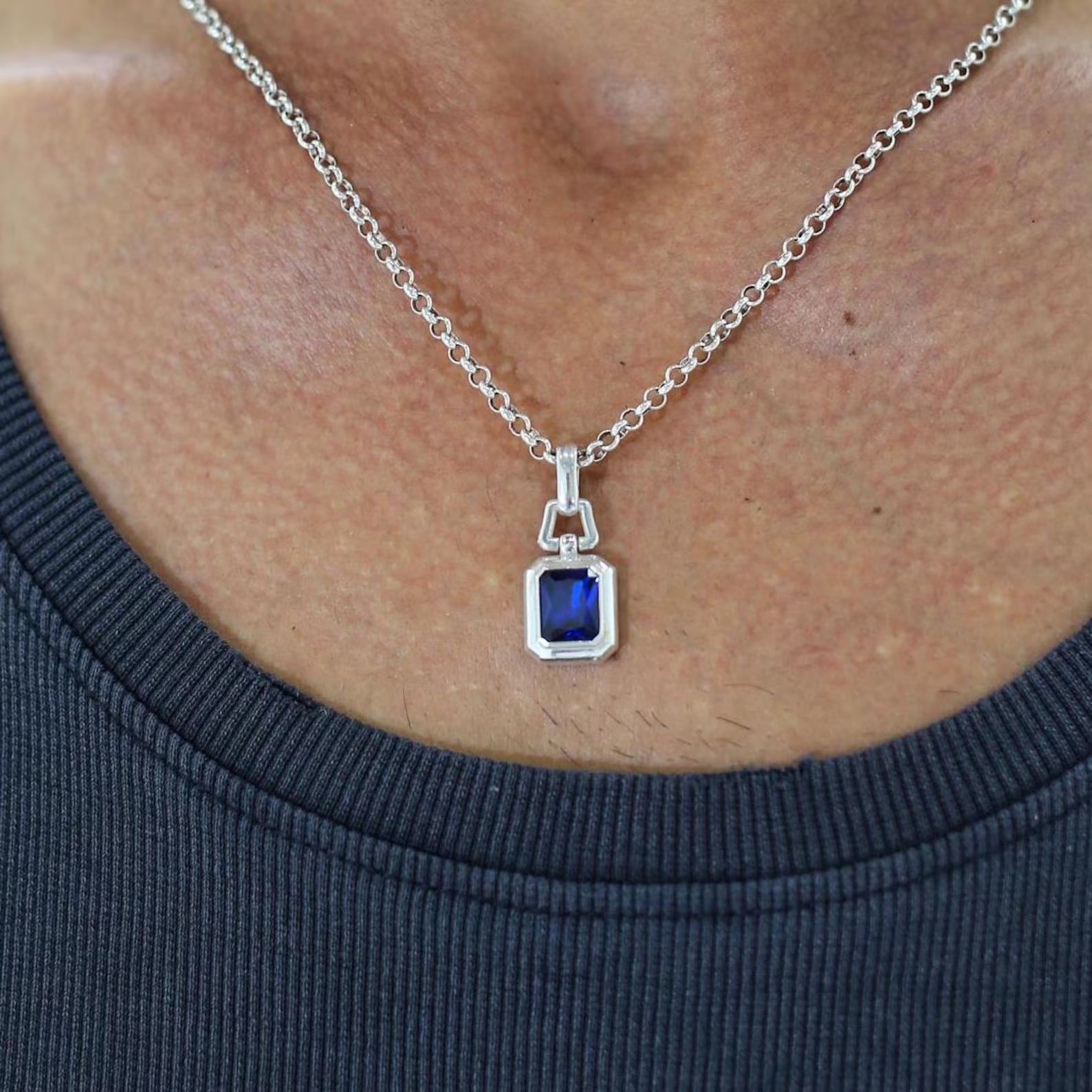 An elegant and powerful unisex necklace crafted in solid sterling silver, featuring a lab sapphire gemstone that glows with deep blue brilliance. Designed for men with strong personal style and appreciation for classic yet bold jewelry.