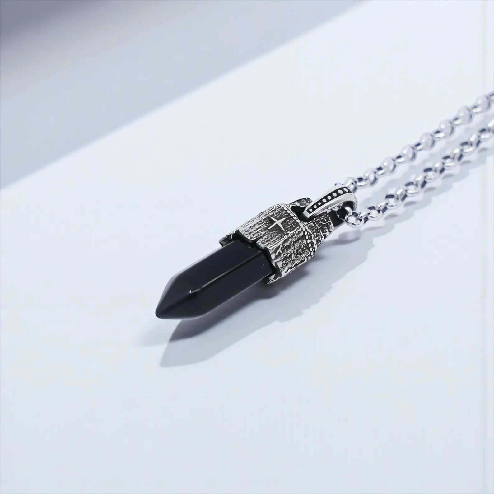 A natural black obsidian stone pendant with pointed shape, framed in solid 925 sterling silver and decorated with a detailed compass symbol, creating a handcrafted vintage men’s necklace perfect for spiritual grounding and protection.