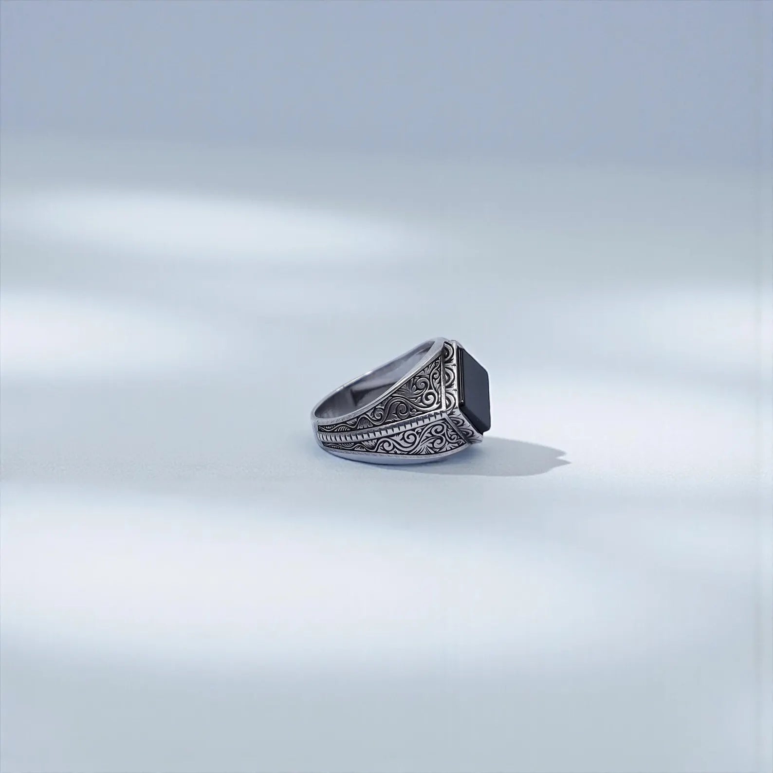 Studio image of a bold men’s onyx signet ring showing its 16mm diameter and engraved baroque patterns, optimized for search phrases like “vintage style signet ring men” and “personalized engraved ring.”