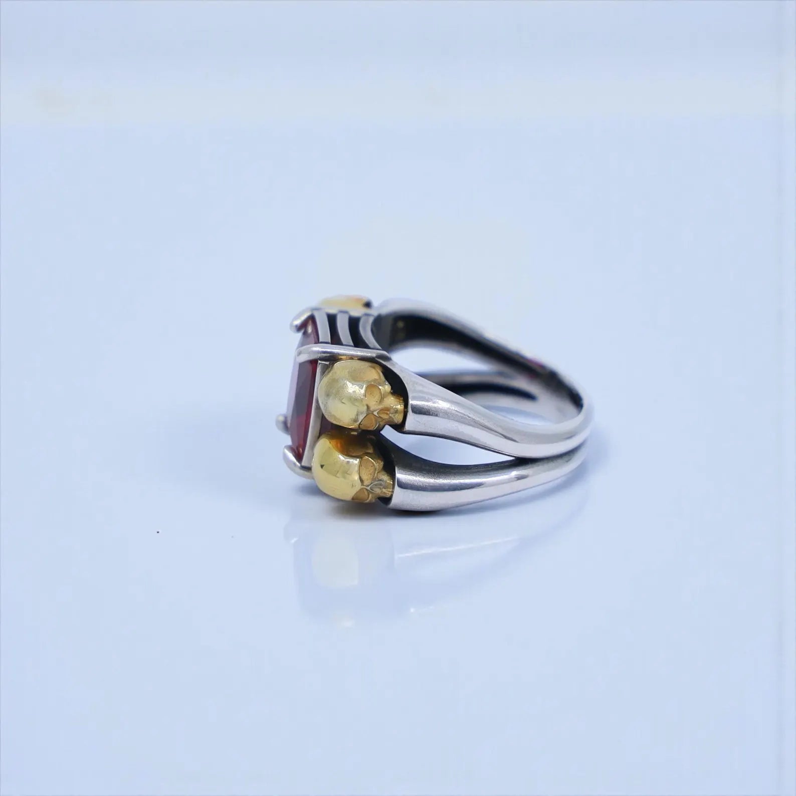 Artistic macro image of the emerald-cut gemstone set in a gothic skull frame, showing fine details and craftsmanship—SEO-focused for emerald jewelry men, green stone skull ring, and statement gothic ring.