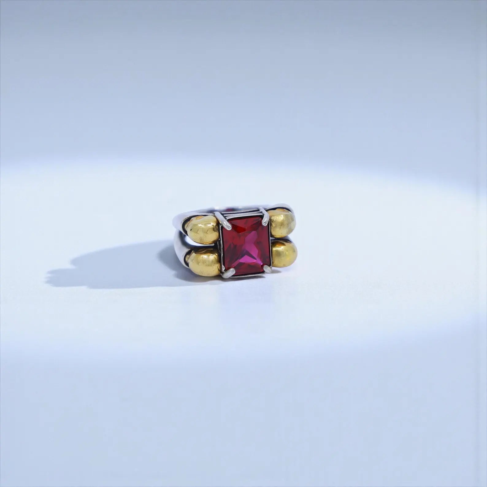 Moody lighting shot of a bold masculine skull ring, combining gold plating, oxidized texture, and emerald brilliance—optimized for dark gothic jewelry, punk biker ring, and mens luxury accessories.