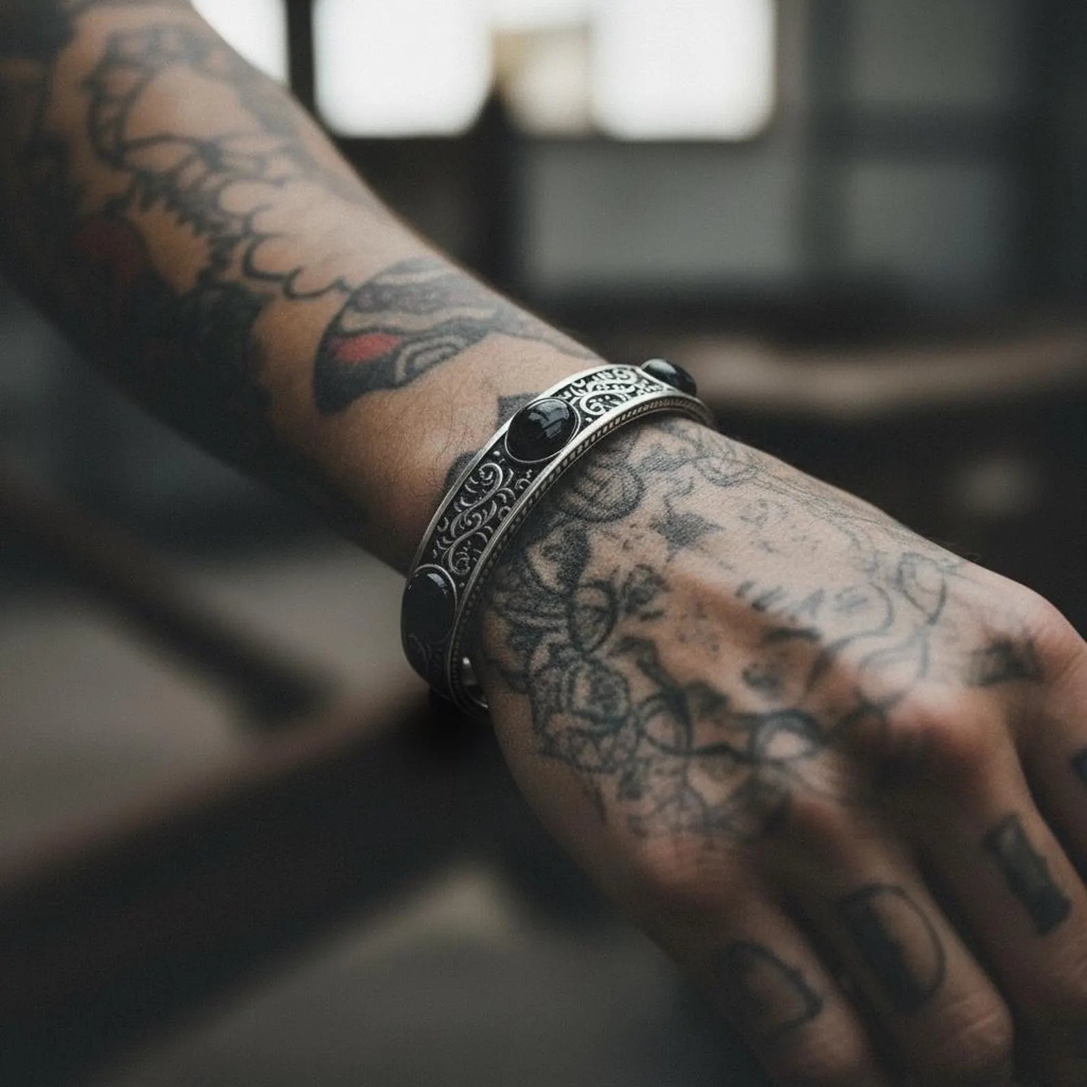 High-quality sterling silver cuff bracelet with three natural onyx stones, expertly handcrafted with biker-inspired engravings and bold masculine proportions for a striking accessory.