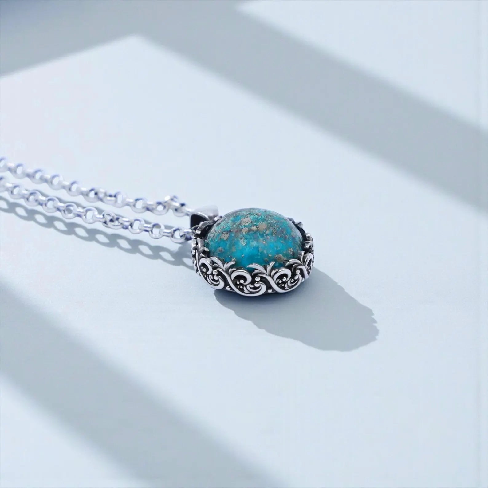 Statement turquoise pendant necklace for men designed with an antique-style sterling silver baroque bezel and a vibrant natural turquoise gemstone known for bringing protection, clarity, and emotional balance; a bold handcrafted jewelry piece that elevates both casual and formal outfits.