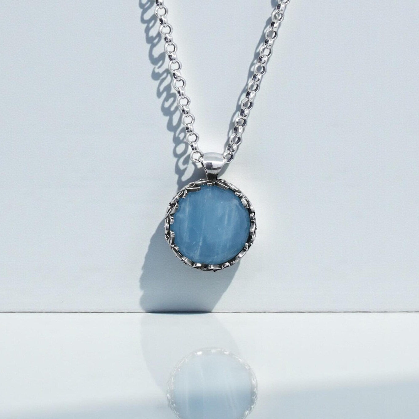 Handcrafted sterling silver aquamarine birthstone pendant necklace featuring a natural aquamarine gemstone set in an intricate floral baroque frame, designed for men and women who appreciate artisan jewelry, calming blue stones, and meaningful handcrafted accessories.