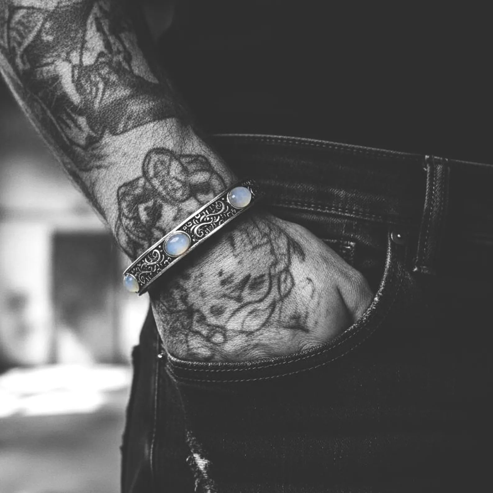 Bold sterling silver moonstone bracelet with hand-engraved Baroque motifs and three shimmering moonstone cabochons. A luxury handcrafted cuff for men who appreciate unique gemstone jewelry.