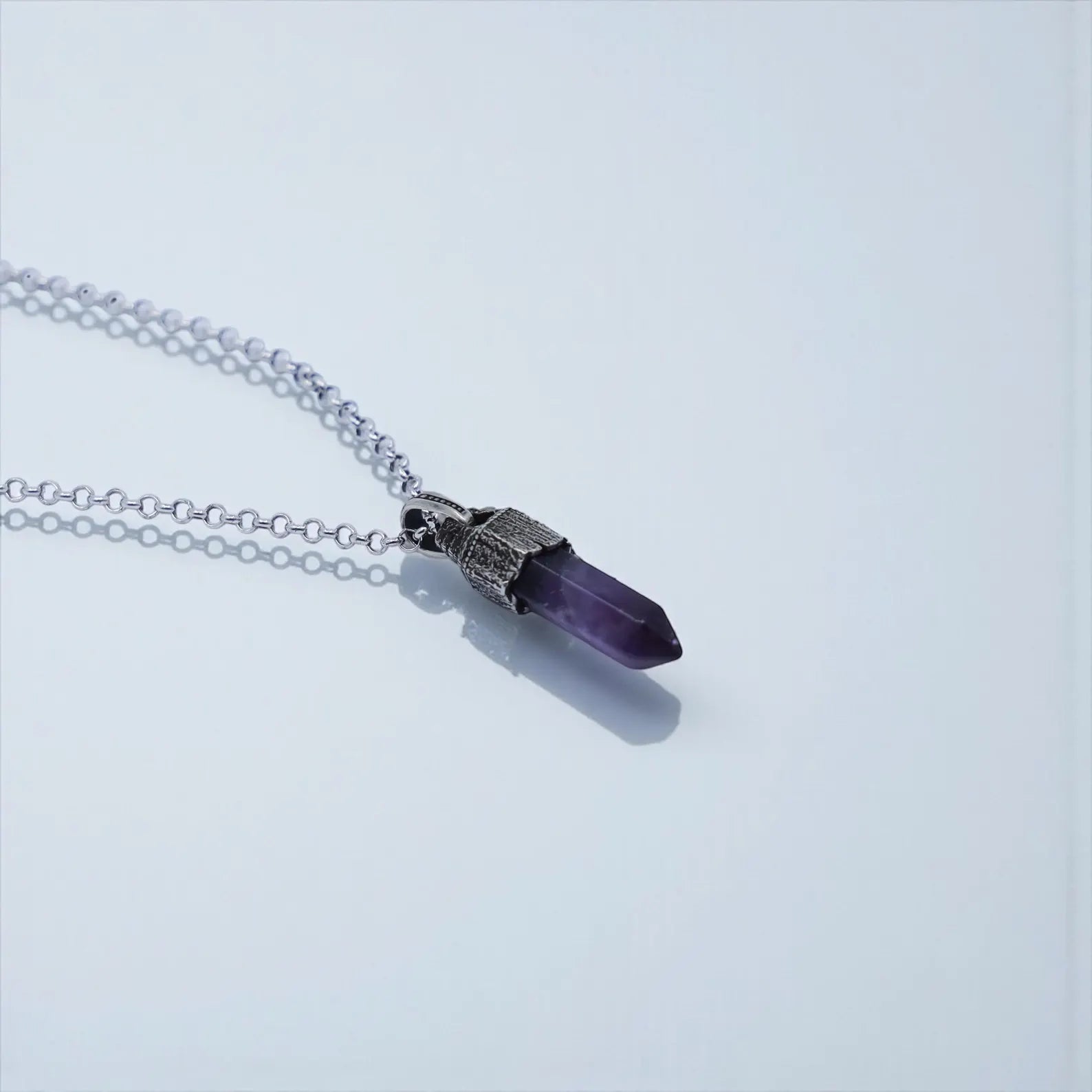 High-detail image of a unisex sterling silver amethyst talisman necklace with a bold handcrafted pendant, featuring natural purple amethyst, spiritual symbolism, and nautical vintage textures.