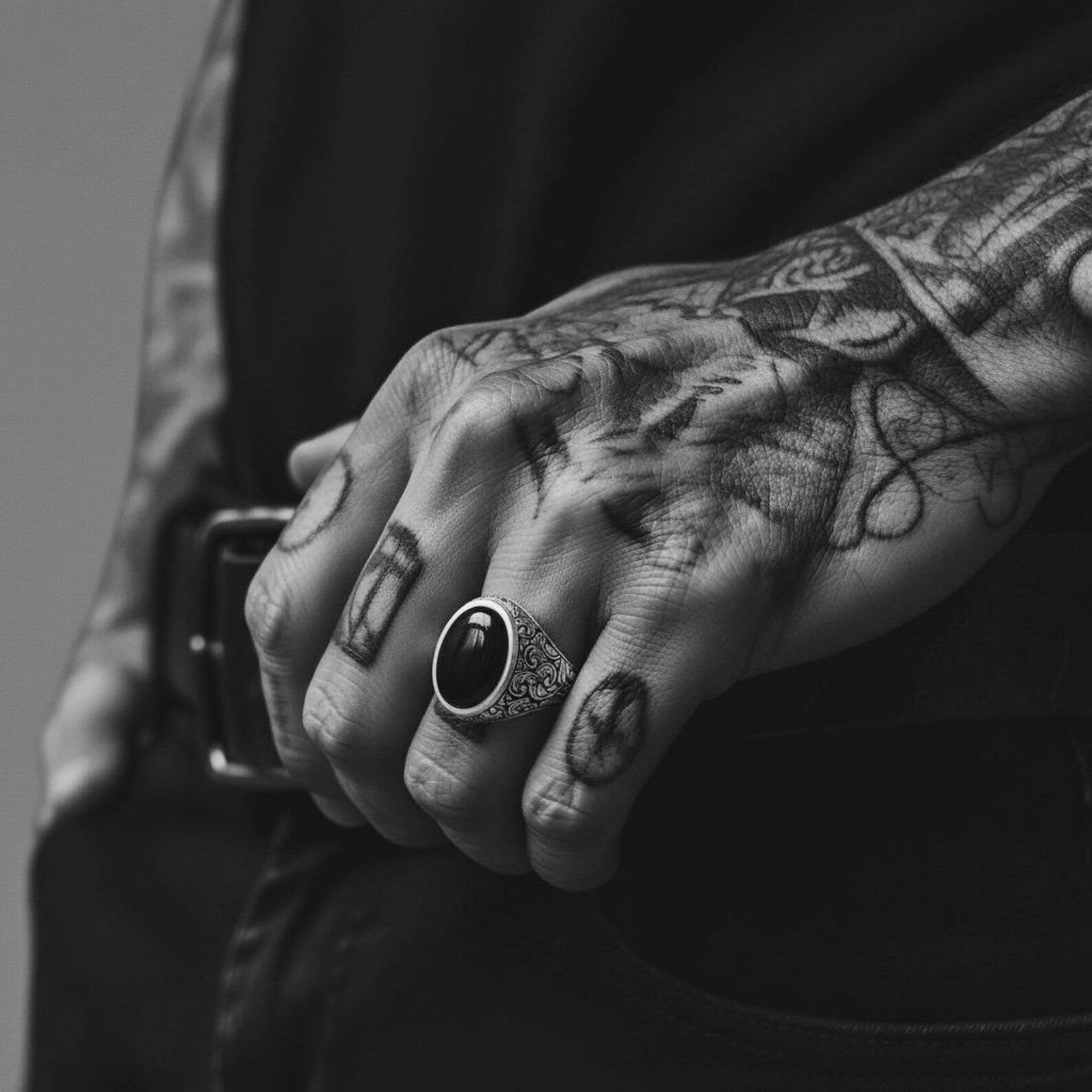 Men’s black onyx signet ring made from nickel-free sterling silver with oxidized baroque patterns, photographed in natural light to emphasize its bold structure, unique texture, and handcrafted artistry.