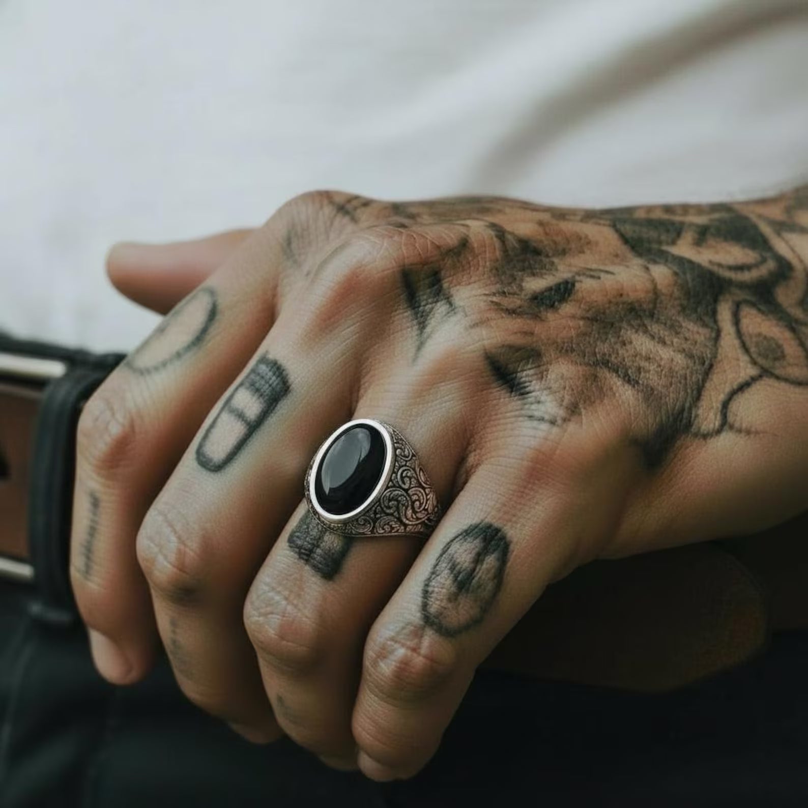Detailed macro shot of a sterling silver black onyx ring with custom engraving options, emphasizing the baroque scroll patterns, oxidized finish, and durable handcrafted construction.