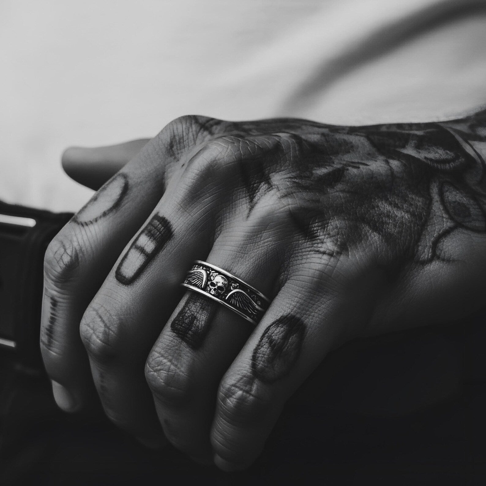 Detailed close-up showing the jawless skull and extended wings on a solid sterling silver band, emphasizing the craftsmanship, gothic identity, and statement-making presence of this men's biker ring.