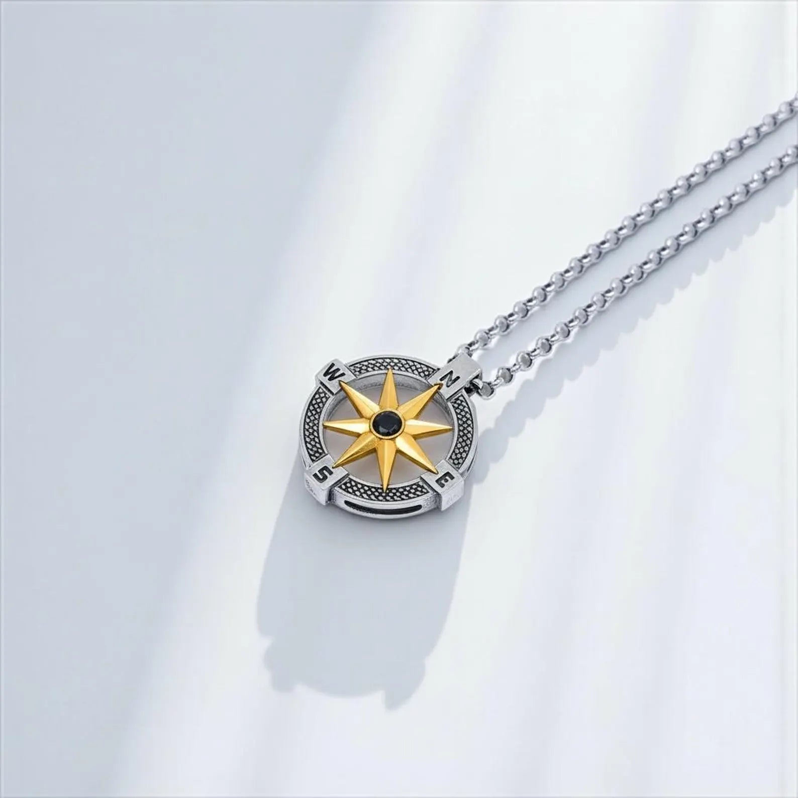 Custom engraved nautical compass pendant necklace in sterling silver featuring a gold north star, symbolic maritime men’s jewelry